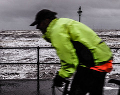 Cyclist viewing the rough sea